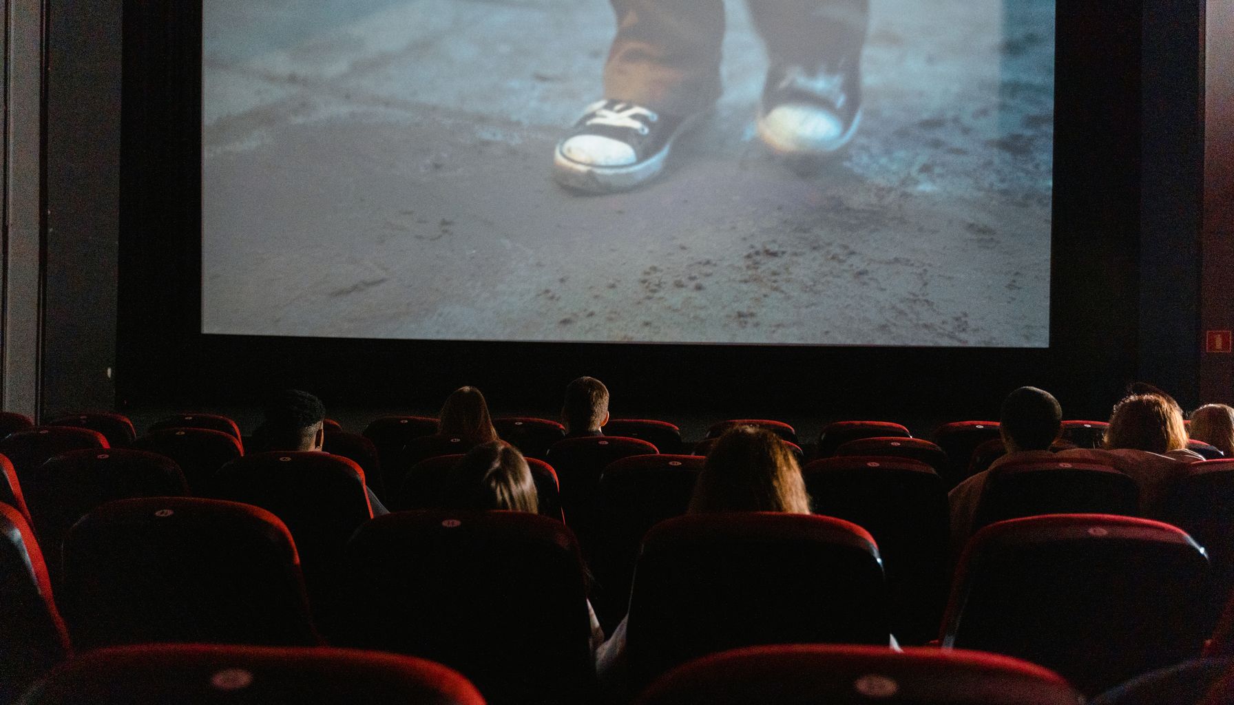 A group of people enjoying a film in a cinema with a large screen.