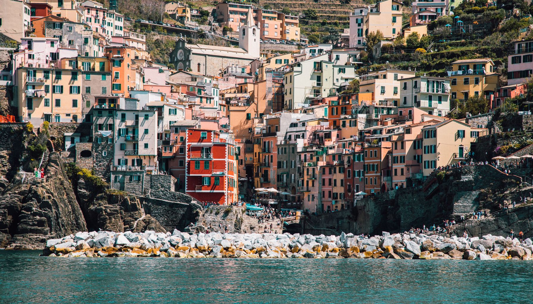 Colorful buildings of Riomaggiore in Liguria, Italy, overlooking the tranquil sea.