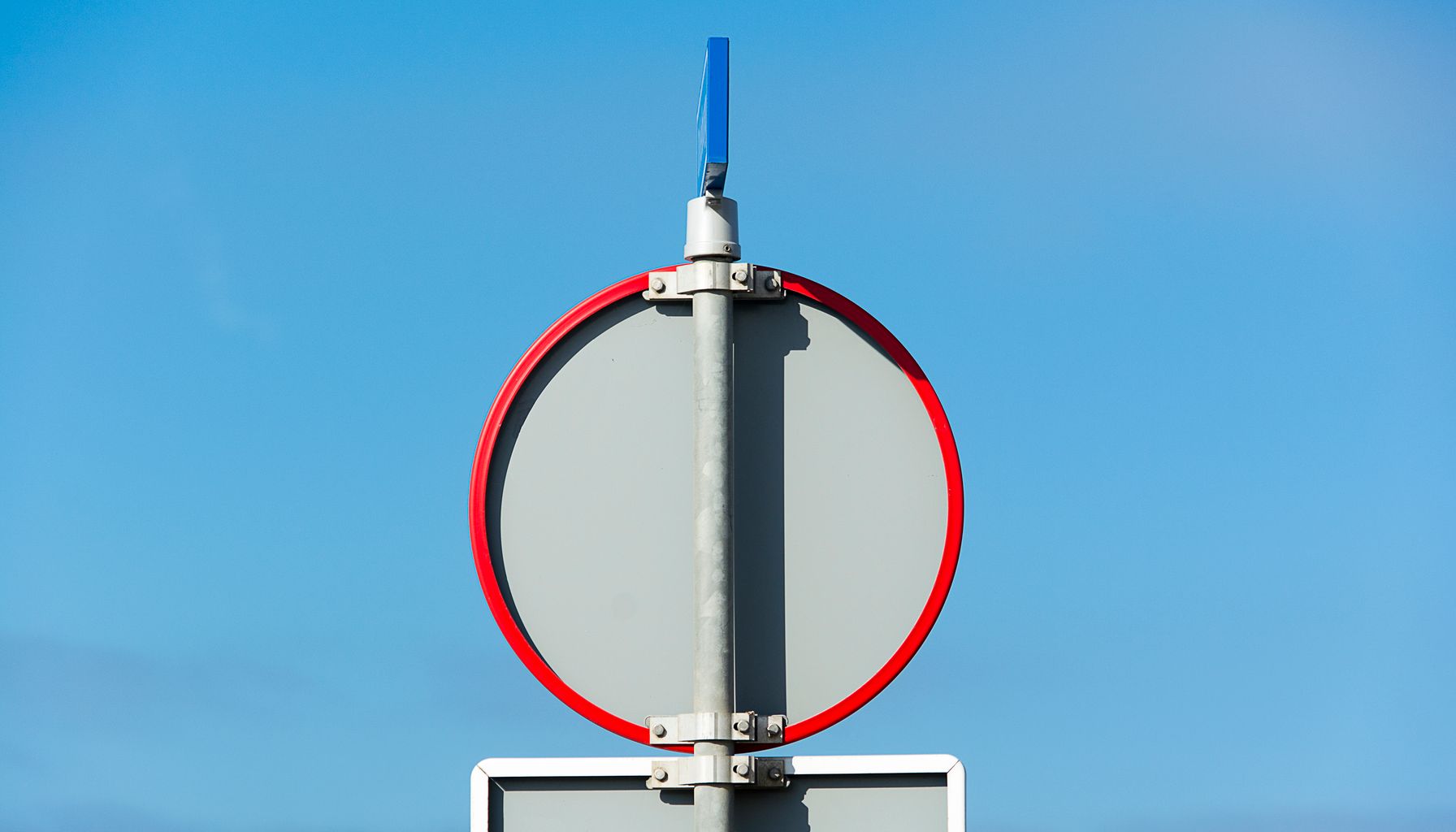 A blank traffic sign against a clear blue sky, perfect for various contexts.