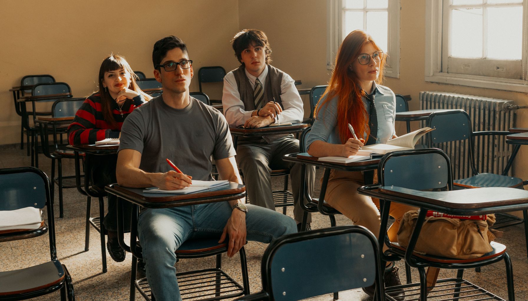 Four university students attentively listening to a lecture in Buenos Aires classroom.