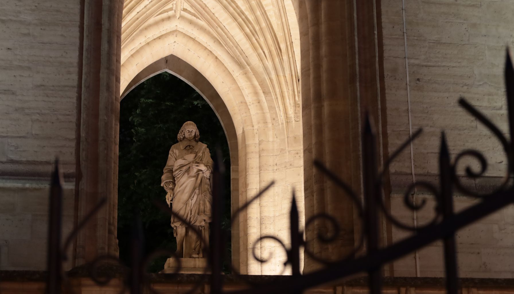 A beautifully lit religious statue at night inside a Gothic church in Paris, France.