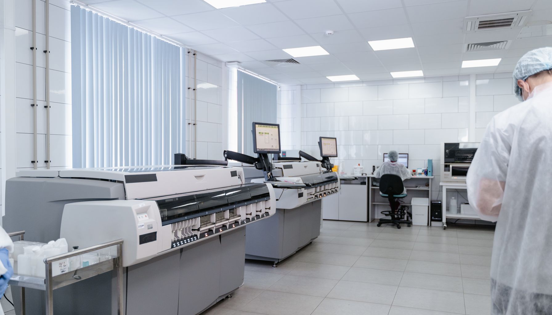 Bright and sterile laboratory featuring high-tech research equipment and professionals at work.