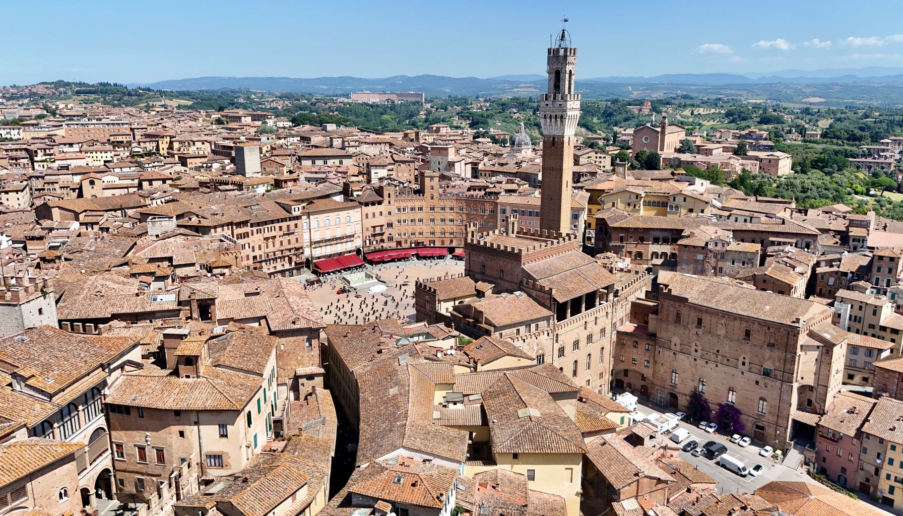 Aerial view of Piazza del Campo and Torre del Mangia in Siena, Tuscany on a sunny day.