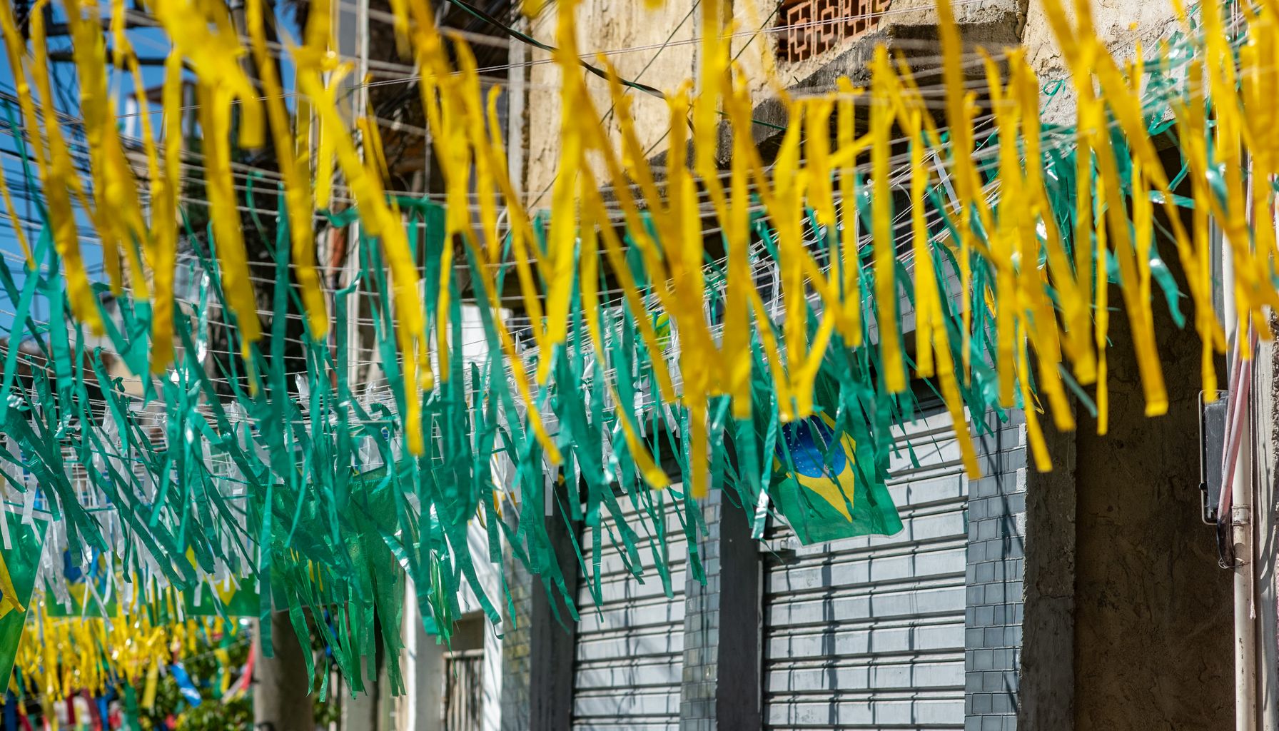 Yellow and green streamers hang in an urban street setting, creating a festive atmosphere.