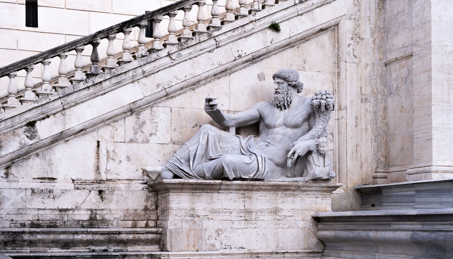 Majestic Roman statue on marble steps in Italy capturing ancient elegance.