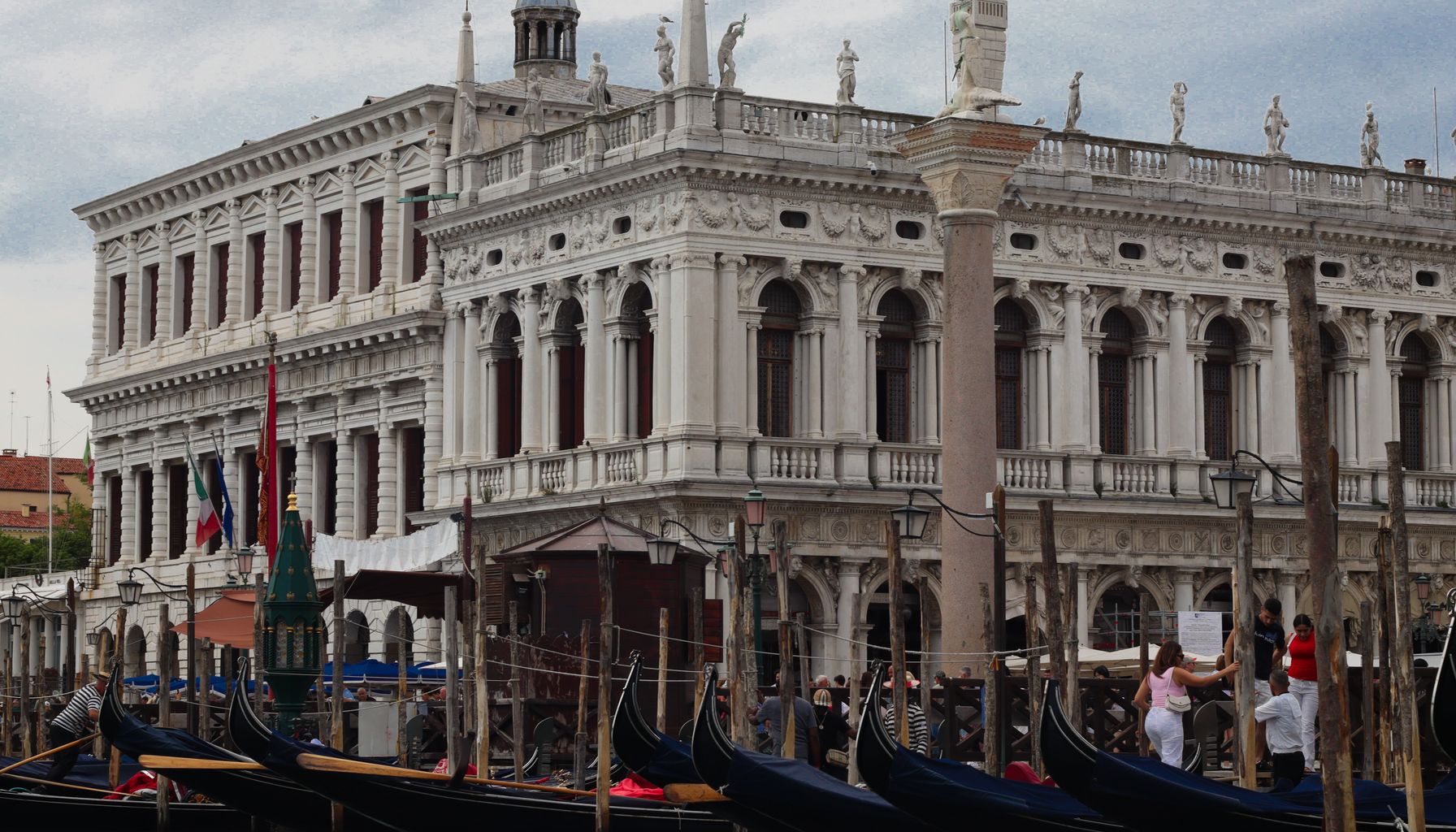 Scenic view of gondolas docked by a historic Venetian building in Venice, Italy.
